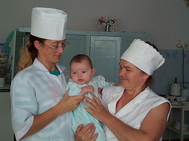 Anna with her caregivers on her last day in the orphanage.